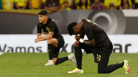 Brasiliens Vinicius Junior (r) kniet vor dem Spiel. - &copy; Joan Monfort/AP