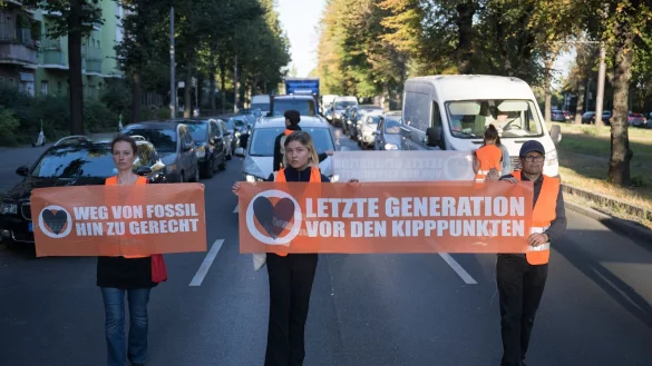 Statt sich auf die Straße zu setzen oder festzukleben, hielten Demonstrantinnen und Demonstranten heute ogenannte Laufblockaden ab und gingen mit Bannern vor dem Verkehr her. - © Sebastian Christoph Gollnow/dpa