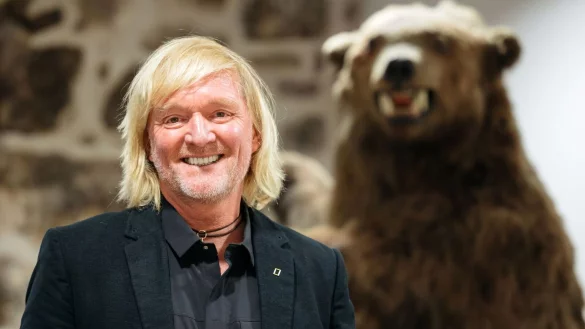 Andreas Kieling 2020 bei der Vernissage zu seiner Ausstellung &laquo;Mit den Grizzlys durch Alaska&raquo; neben einem Pr&auml;parat eines Grizzlyb&auml;ren. - &copy; Michael Reichel/dpa
