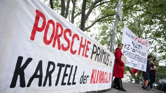 Demonstranten mit Plakaten vor Beginn der Porsche-Hauptversammlung in Stuttgart. - &copy; Marijan Murat/dpa