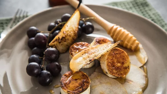 Ein Klassiker unter den Vorspeisen: Die Süße der Weintrauben und der karamellisierten Birnenscheiben balancieren die herzhafte Würze von gebratenem Ziegenkäse aus. - © Christin Klose/dpa-tmn