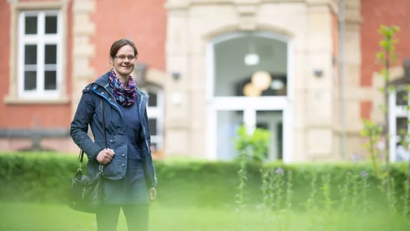 Julia Kistner, Genesungsbegleiterin, steht vor dem Zentrum für Psychiatrie des Universitätsklinikums Gießen und Marburg. - © Sebastian Gollnow/dpa