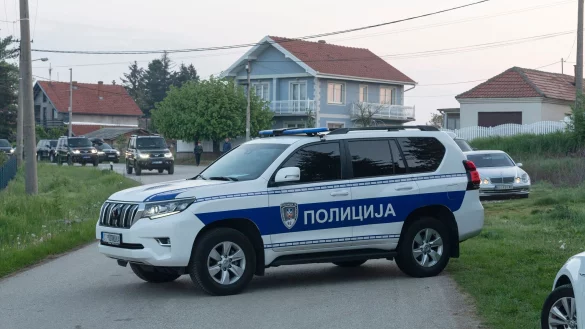 Ein Polizeifahrzeug blockiert den Eingang zum Dorf Dubona, etwa 50 Kilometer südlich von Belgrad. - © Marko Drobnjakovic/AP