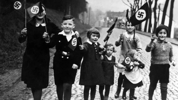 Propagandafoto f&uuml;r die Presse: Kinder mit Hakenkreuzfahnen in einer Szene aus der Dokumentation &laquo;Berlin 1933 - Tagebuch einer Gro&szlig;stadt&raquo;. - &copy; Scherl/S&uuml;ddeutsche Zeitung /RBB/dpa