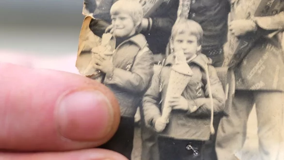 Kai Oppermann, in DDR-Kinderheimen gro&szlig; geworden, zeigt ein Foto von seiner Einschulung. In der Bildmitte ist er in der vorderen Reihe mit Zuckert&uuml;te zu sehen. Links daneben steht sein Bruder Patrick. - &copy; Sebastian Willnow/dpa