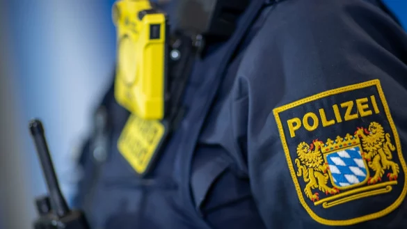 Eine Polizistin tr&auml;gt ein Abzeichen der bayerischen Polizei. - &copy; Daniel Karmann/dpa/Symbolbild