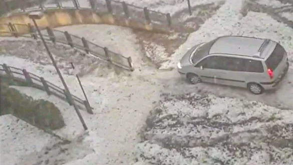 Ein Van f&auml;hrt nach einem heftigen Hagelschauer &uuml;ber einen winterlich anmutenden Parkplatz in Worms. - &copy; Einsatz-Report24/dpa