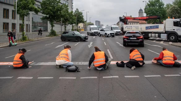 Aktivisten der Letzten Generation während einer Straßenblockade. - © Paul Zinken/dpa