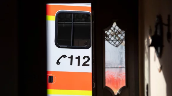 Ein Rettungswagen parkt vor der ge&ouml;ffneten T&uuml;r eines Wohnhauses. - &copy; Boris Roessler/dpa/Symbolbild