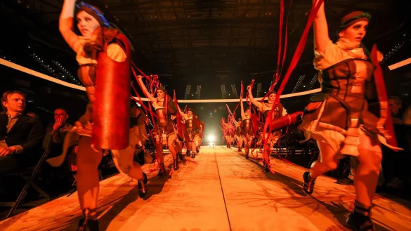Darstellerinnen und Darsteller rennen durch das Publikum auf die Bühne in der Barclays-Arena Hamburg bei einer Medienvorführung nach einer Pressekonferenz zum Opern-Spektakel «Aida» von Giuseppe Verdi. - © Christian Charisius/dpa