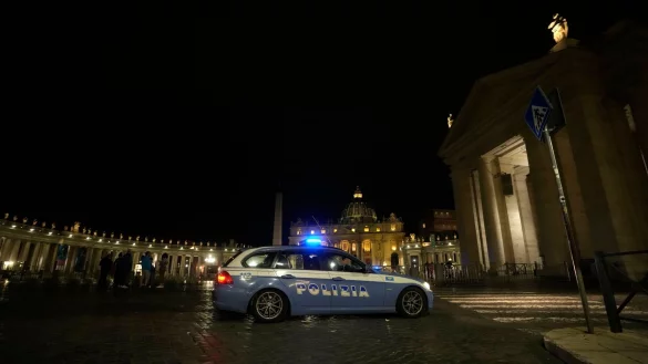 Ein italienisches Polizeiauto f&auml;hrt am sp&auml;ten Abend vor dem Petersplatz im Vatikan vorbei. - &copy; Andrew Medichini/AP/dpa