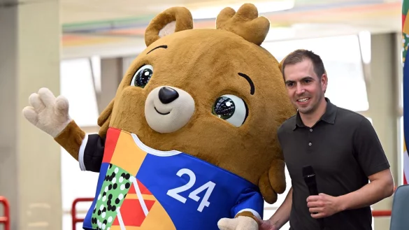 Das noch namenlose Maskottchen steht mit Turnierdirektor Philipp Lahm auf der B&uuml;hne. - &copy; Federico Gambarini/dpa