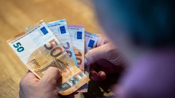 Ein &auml;lterer Mann sitzt an einem Tisch und z&auml;hlt Geld. - &copy; Lino Mirgeler/dpa