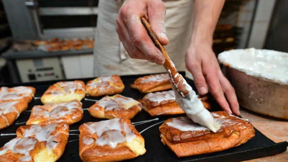 Ein B&auml;ckermeister pinselt Zuckerguss auf s&uuml;&szlig;es Geb&auml;ck in seiner Backstube. - &copy; Martin Schutt/dpa-Zentralbild/dpa
