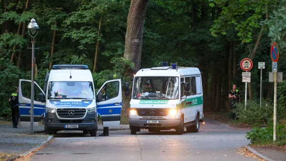 Polizeiautos fahren aus dem Wald in dem sich die Raubkatze befinden soll. - &copy; Gerald Matzka/dpa
