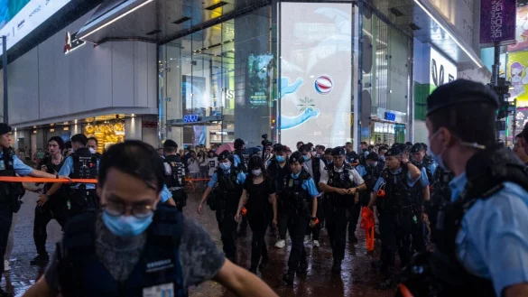 Polizeibeamte nehmen am Vorabend des 34. Jahrestages des Massakers auf dem Platz des Himmlischen Friedens eine Bürgerin mit. - © Louise Delmotte/AP