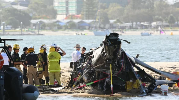 Rettungskr&auml;fte sind neben dem abgest&uuml;rzten Hubschrauber in der N&auml;he von Seaworld an der Gold Coast im Einsatz. - &copy; Dave Hunt/AAP/dpa