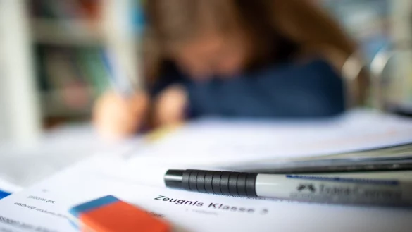 Ein Zeugnis liegt dem Schreibtisch einer Sch&uuml;lerin. - &copy; Jonas G&uuml;ttler/dpa/Illustration