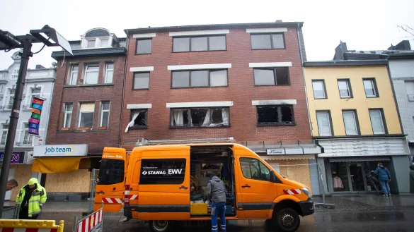 Ein Fahrzeug der Stadtwerke steht in der Neustraße vor dem beschädigten Gebäude. - © Thomas Banneyer/dpa/Archivbild