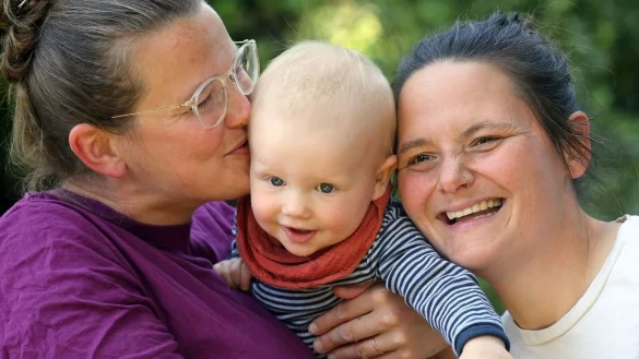 Juliane (l-r), der zehn Monate alte Remo und Jana in ihrem Garten hinter ihrem Haus in Berlin. - &copy; Wolfgang Kumm/dpa/Produktion