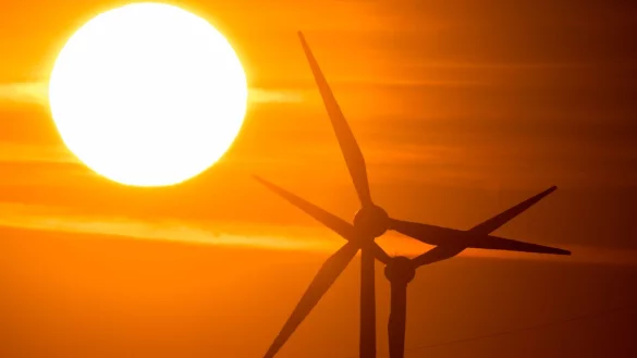 Die Sonne geht hinter Windr&auml;dern auf. - &copy; Julian Stratenschulte/dpa/Symbolbild