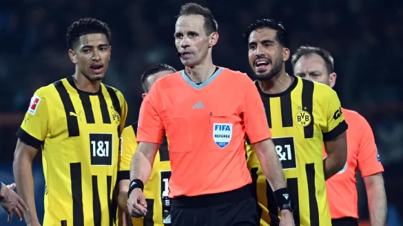 Dortmunds Jude Bellingham (l) und Emre Can (r) versuchen nach dem Spiel mit Schiedsrichter Sascha Stegemann (M) zu sprechen. - &copy; Federico Gambarini/dpa/Archivbild