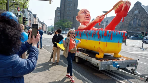 Teilnehmer einer Demonstration stehen vor einem Karnevalswagen. - &copy; Henning Kaiser/dpa