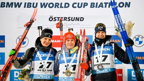 Benedikt Doll (M) feiert auf dem Podium seinen Sieg. Daneben: Tommaso Giacomel (l), Zweitplatzierter aus Italien, und Vetle Sjastad Christiansen, Drittplatzierter aus Schweden. - &copy; Anders Wiklund/TT News Agency/AP/dpa