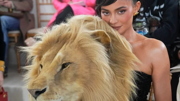 Kylie Jenner hinter einem t&auml;uschend echt aussehenden L&ouml;wenkopf. - &copy; Michel Euler/AP/dpa