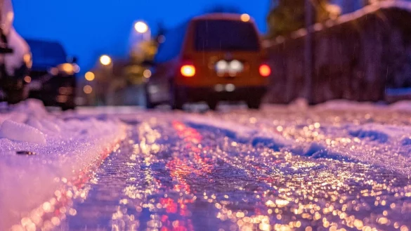 Eine d&uuml;nne Eisschicht &uuml;berzieht am fr&uuml;hen Morgen eine Stra&szlig;e. - &copy; Armin Weigel/dpa/Symbolbild