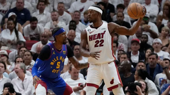 Miami Heat-Stürmer Jimmy Butler (22) versucht den Ball zu passen, während Denver Nuggets-Guard Kentavious Caldwell-Pope (5) verteidigt. - © Wilfredo Lee/AP