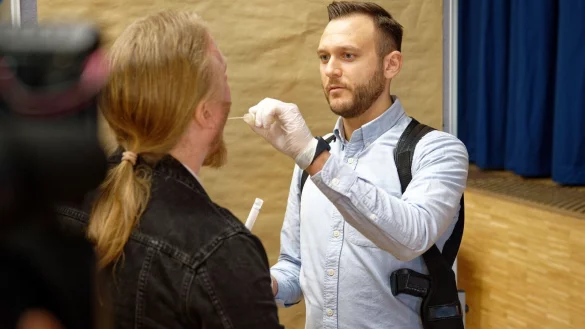 Ein Polizeibeamter demonstriert in einer gestellten Szene vor Beginn eines DNA-Massentests die Abnahme einer Speichelprobe. - &copy; Henning Kaiser/dpa