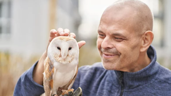 Jose Lay, Hospiz-Bewohner, streichelt die Wei&szlig;gesichtseule Merlin. - &copy; Sascha Ditscher/dpa