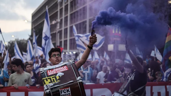 Israelische Demonstranten halten Fahnen und z&uuml;nden Fackeln w&auml;hrend eines Protestes gegen die Pl&auml;ne der Regierung von Premierminister Netanjahu, das Justizsystem zu reformieren. - &copy; Ilia Yefimovich/dpa