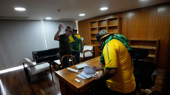 Bolsonaro-Anh&auml;nger w&uuml;hlen sich in einem B&uuml;ro des Palacio do Planalto, dem offiziellen Sitz des brasilianischen Pr&auml;sidenten, durch Papiere. - &copy; Eraldo Peres/AP/dpa