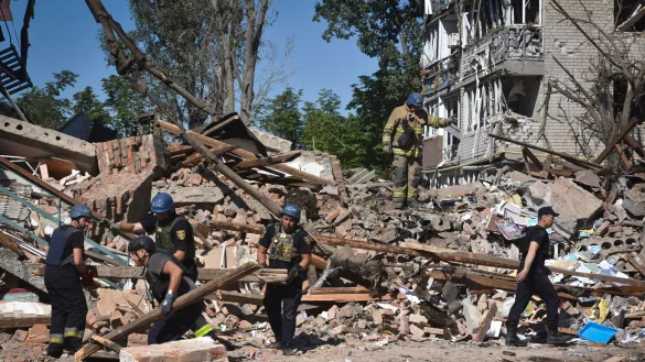 Ukrainische Rettungskr&auml;fte arbeiten nach einem russischen Angriff auf Orichiw in den Tr&uuml;mmern eines zerst&ouml;rten Geb&auml;udes. - &copy; Andriy Andriyenko/AP/dpa