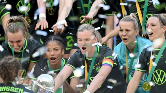 Die Wolfsburger Spielerinnen feiern im Anschluss an das Finale mit dem Pokal. - &copy; David Inderlied/dpa