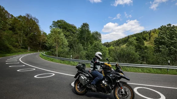Ein Motorradfahrer f&auml;hrt bei Vossenack durch eine Serpentine mit aufgemalten Kreisen auf der Fahrbahn. - &copy; Oliver Berg/dpa
