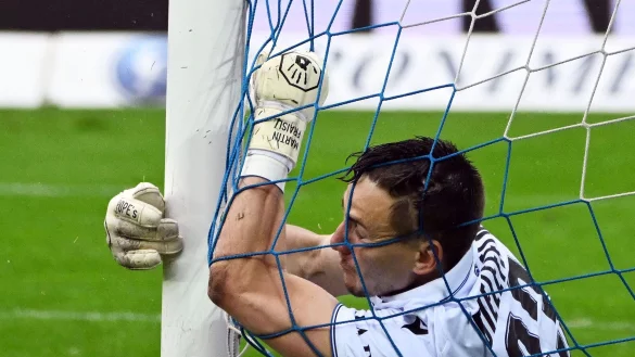 Der Bielefelder Torwart Martin Fraisl liegt nach einer Aktion am Tornetz. - © Uli Deck/dpa