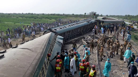 Rettungskr&auml;fte und Soldaten versuchen nach dem Ungl&uuml;ck in der s&uuml;dpakistanischen Provinz Sindh, Menschen aus dem entgleisten Zug zu befreien. - &copy; Pervez Masih/AP/dpa