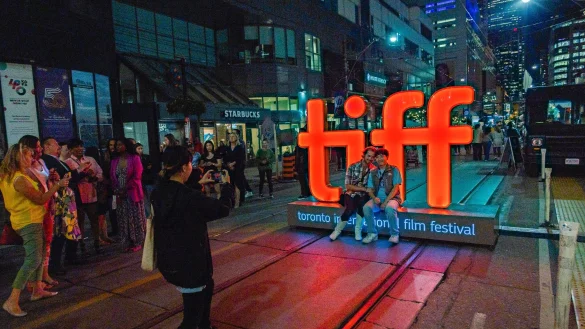 Menschen machen Fotos vor einer Leuchtreklame vor der TIFF Bell Lightbox w&auml;hrend des 48. Toronto International Film Festivals. - &copy; Joel C Ryan/Invision/AP/dpa