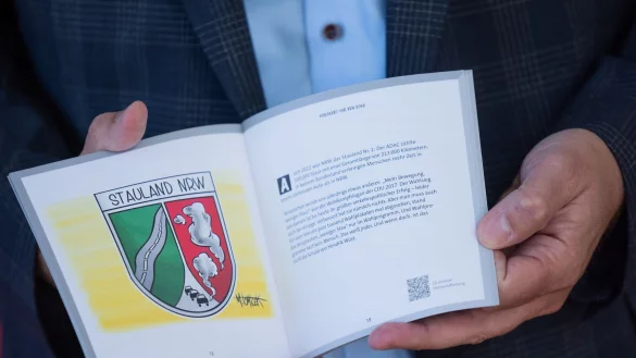 Jochen Ott, Vorsitzender der SPD-Fraktion, h&auml;lt ein Buch mit der Aufschrift &laquo;1 Jahr Schwarz-Gr&uuml;n in Bildern&raquo; mit Karikaturen von Tomicek in der Hand. - &copy; Rolf Vennenbernd/dpa