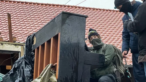 Ein Aktivist spielt Klavier, w&auml;hrend die Polizei den besetzten Ort r&auml;umt. - &copy; Christoph Driessen/dpa