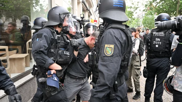 Polizisten halten einen Teilnehmer aus einer Demonstration in Leipzig fest. - © Hendrik Schmidt/dpa