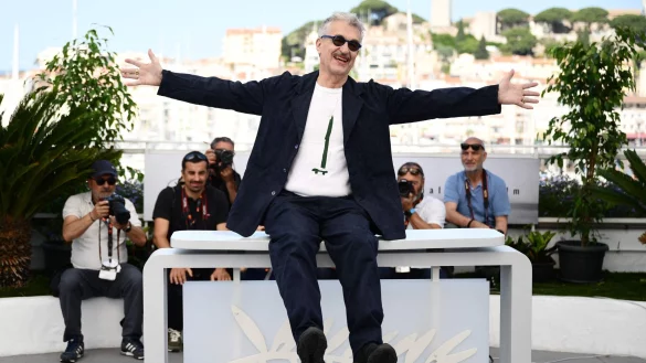 Wim Wenders gestikuliert w&auml;hrend eines Fototermins f&uuml;r den Film &laquo;Perfect Days&raquo; in Cannes. - &copy; Christophe Simon/AFP/dpa