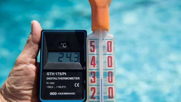 Mit einem Digital-Thermometer (l) misst am 20.06.2017 in einem Freibad ein Bademeister eine Wassertemperatur von 24,3 Grad Celsius. - &copy; picture alliance / Daniel Karmann/dpa/Archivbild