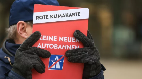 Ein Mann hält ein Plakat mit der Aufschrift «Keine neuen Autobahnen». - © Oliver Berg/dpa