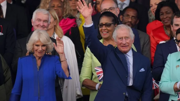 Der britische K&ouml;nig Charles und K&ouml;nigin Camilla winken beim Konzert auf Schloss Windsor. - &copy; Yui Mok/PA Wire/dpa