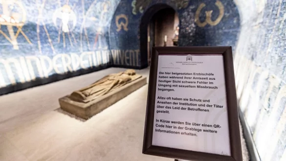 In der Grabkammer der Krypta steht ein Hinweisschild zu den Fehlern der dort beigesetzten Bisch&ouml;fe. - &copy; Christoph Reichwein/dpa