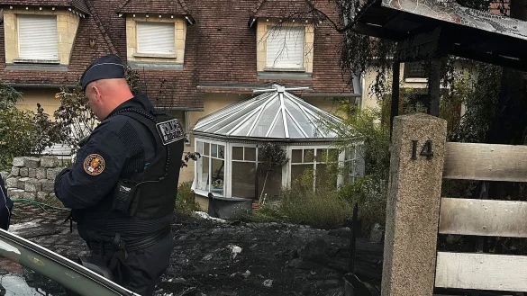 Ein Polizist steht vor dem Haus des B&uuml;rgermeisters Vincent Jeanbrun. Randalierer hatten das Haus in der Nacht mit einem Auto gerammt und Feuer gelegt. - &copy; Nassim Gomri/AFP/dpa